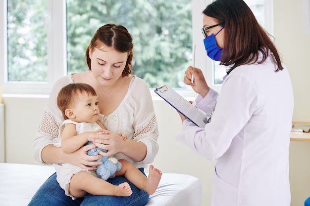 Pediatrician explaining childhood vaccination to a mother during a baby health visit