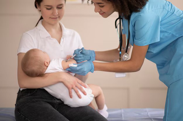 Mother holding her infant during a routine vaccination visit with a pediatrician